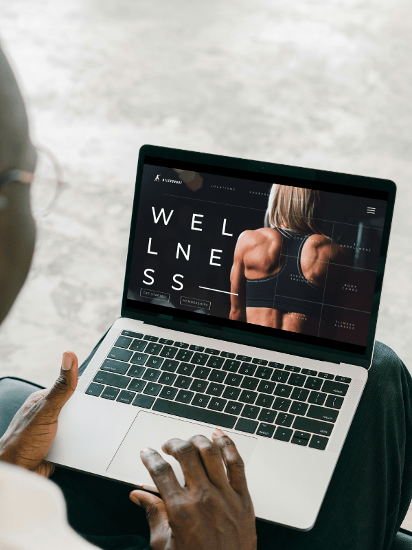 A fitness trainer website is showcased on a laptop created by Sprout Marketing and Design, a local web design service in Chandler AZ