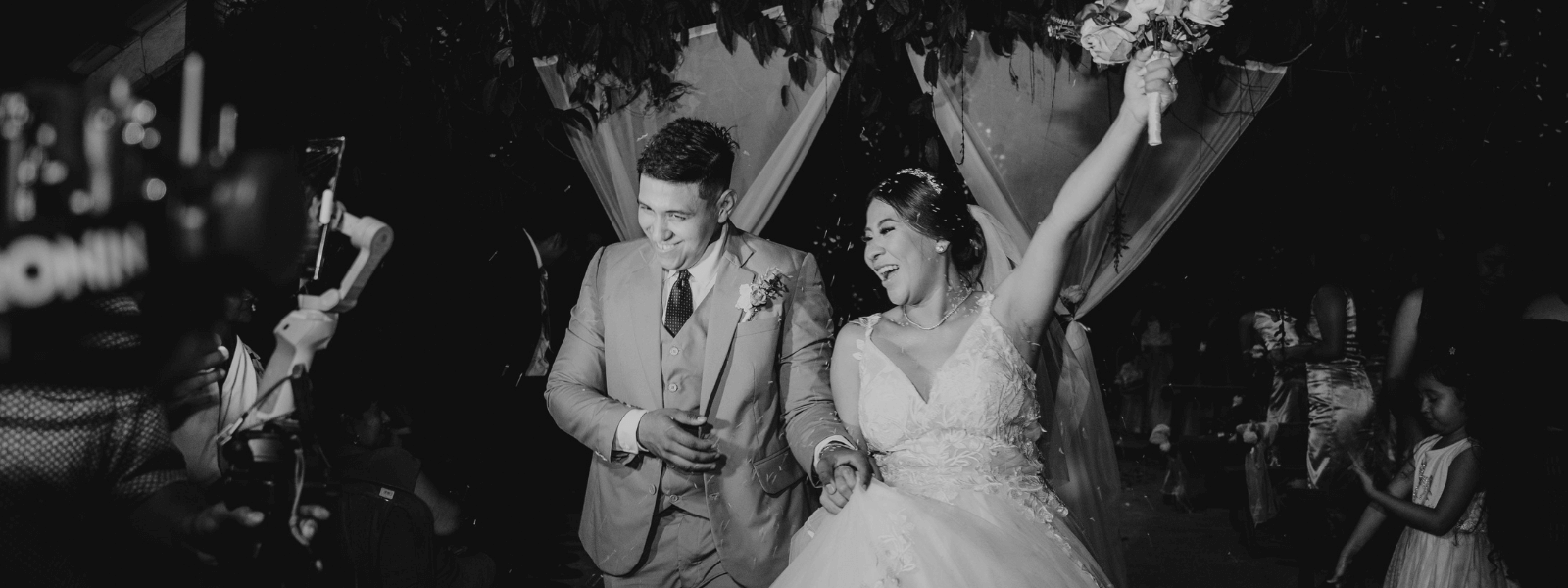 Black and white photo of a couple laughing at their reception