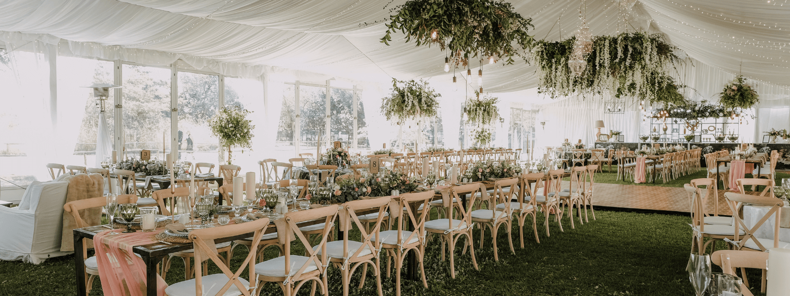 Wedding reception set up under a tent with long guest tables