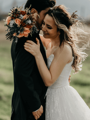 Bride embracing the groom while holding her bouquet