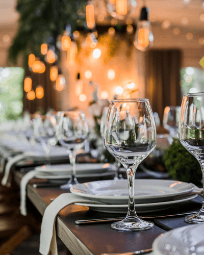 Glassware and place settings on a candlelit reception table
