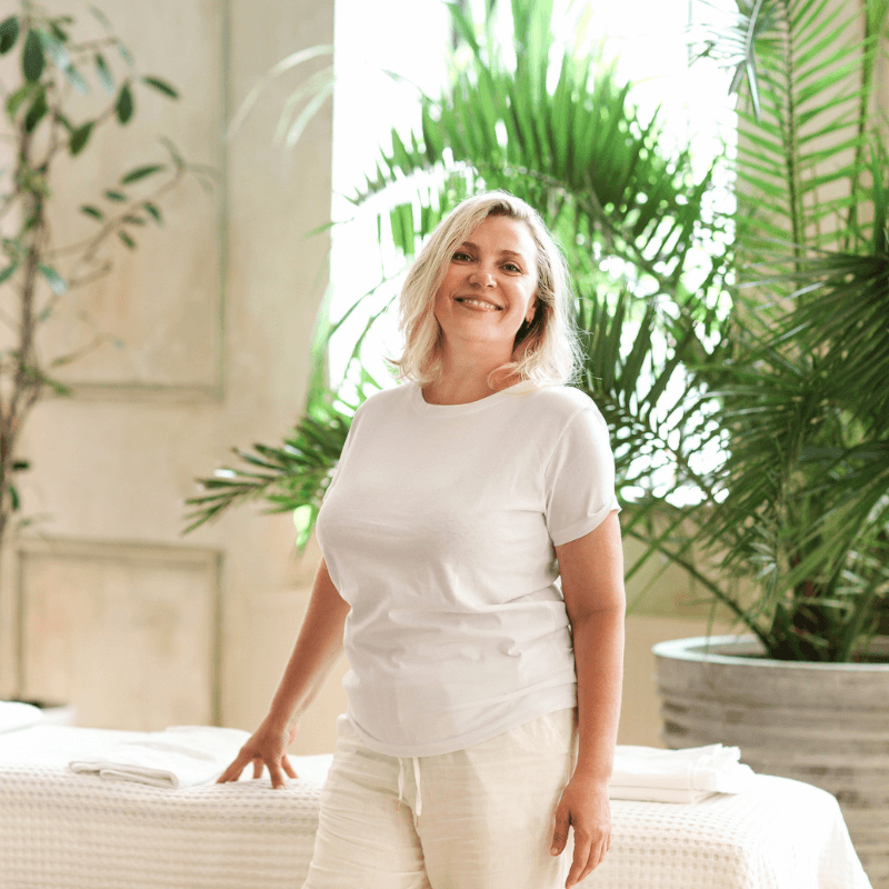 Nora Whitfield, licensed massage therapist, standing in her Richmond studio