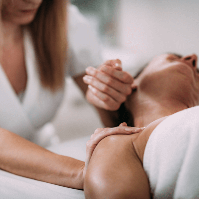 Massage therapist working on a client’s neck and shoulders