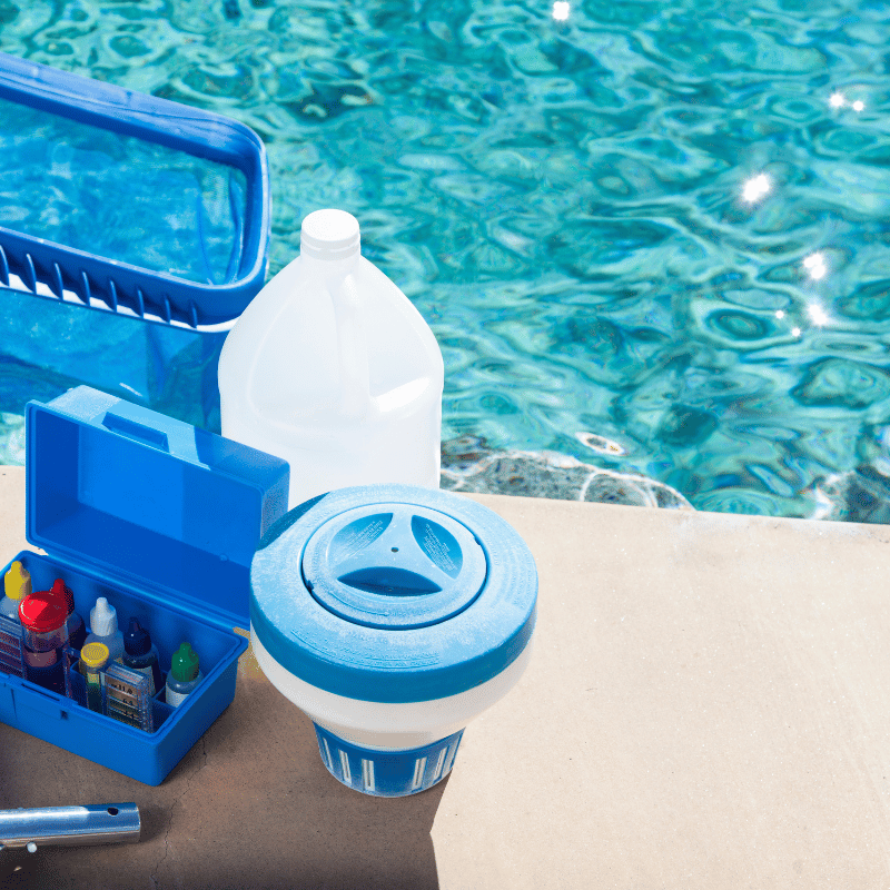 Pool chemicals and testing supplies beside the water