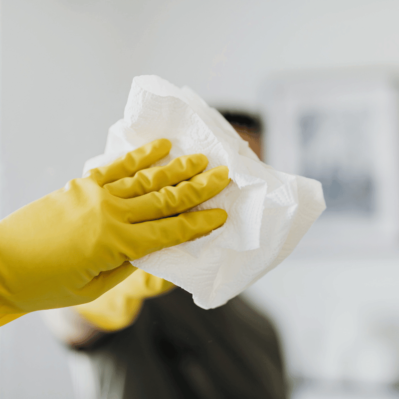 Cleaner polishing a bathroom mirror