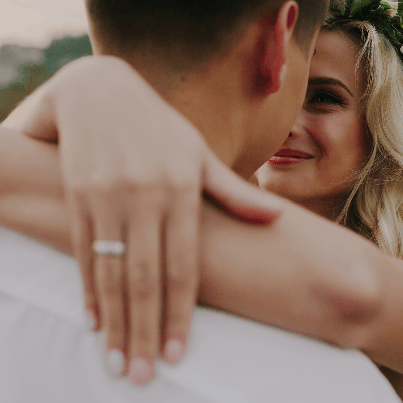 Couple holding hands with the engagement ring in view