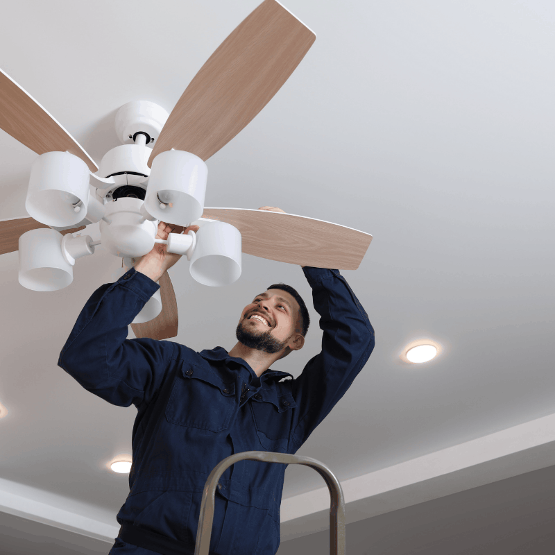 Electrician installing a ceiling fan