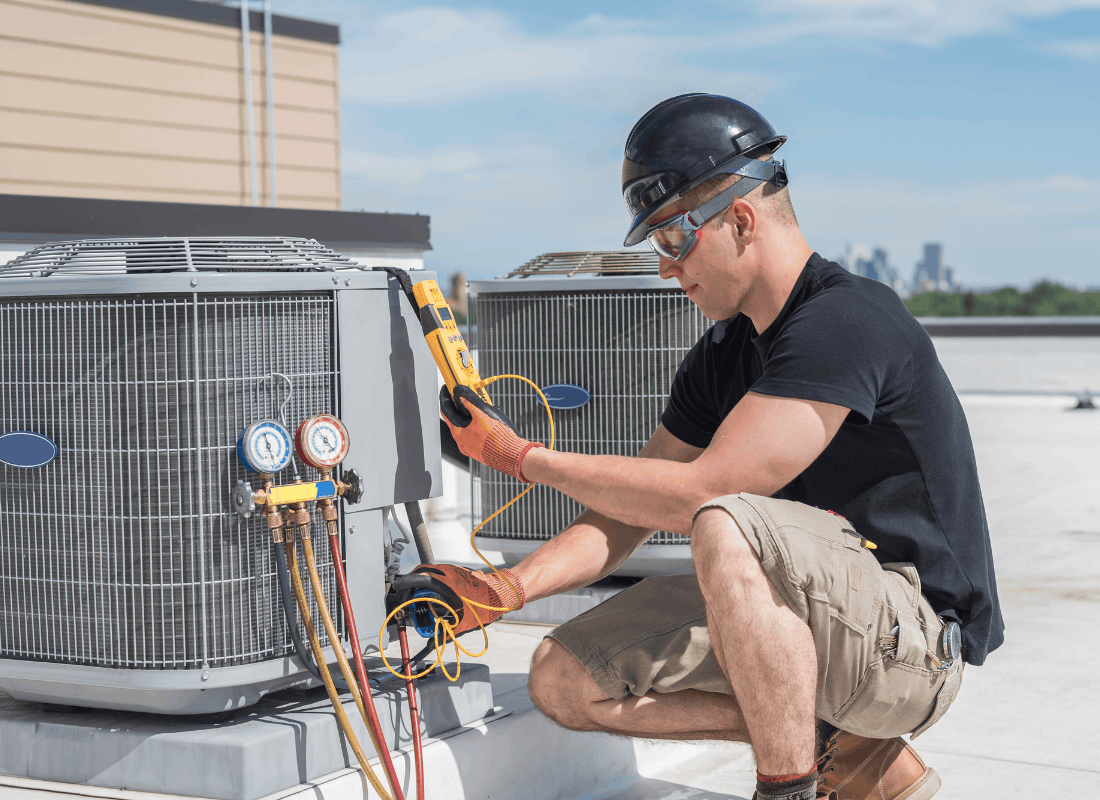 Technician testing a rooftop HVAC unit