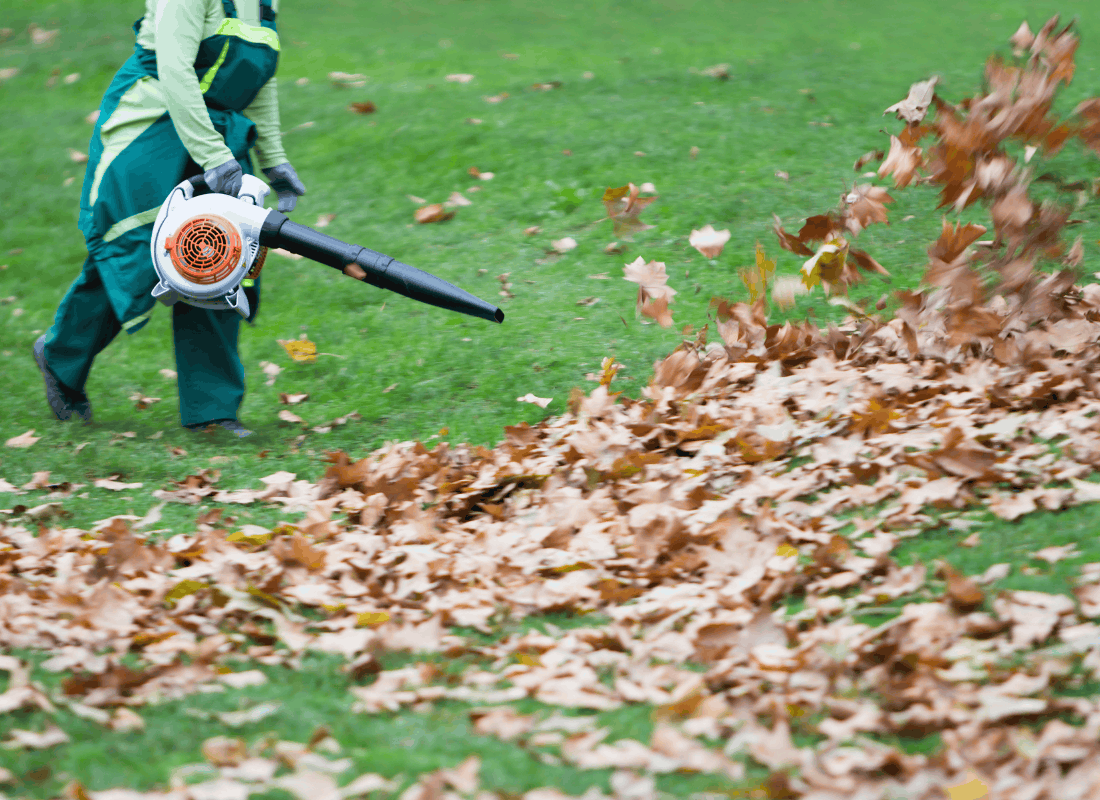 Worker clearing leaves from an outdoor area