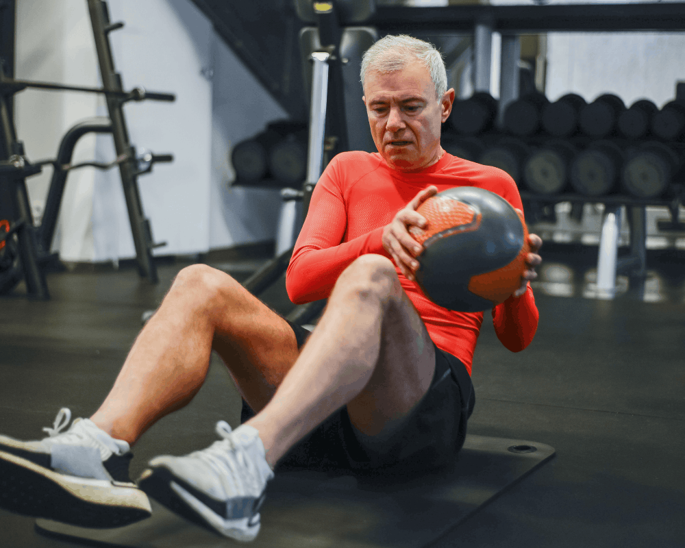 Older adult exercising with guidance from a personal trainer
