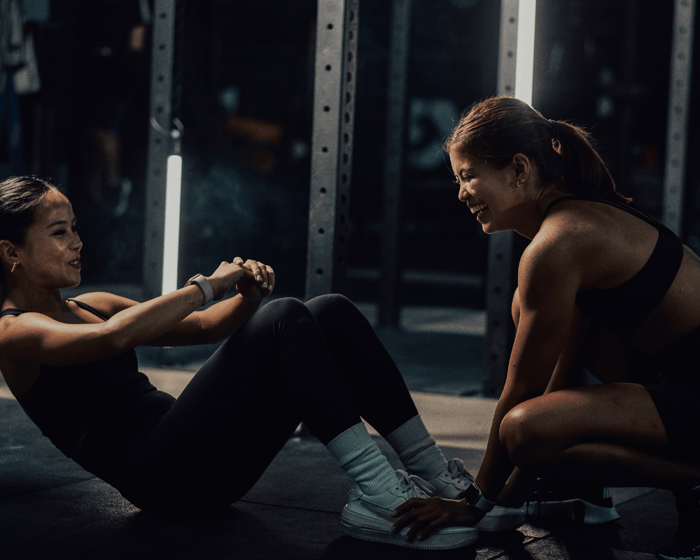 Trainer coaching a client through a strength exercise
