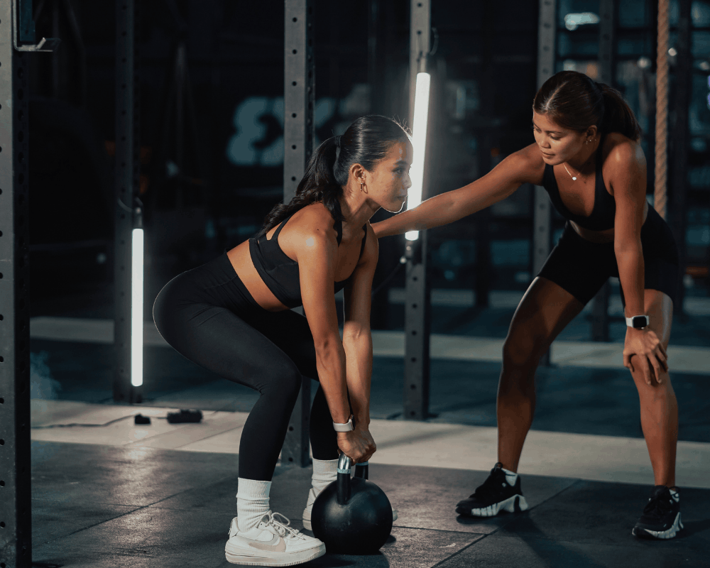 Personal trainer coaching a client in the gym