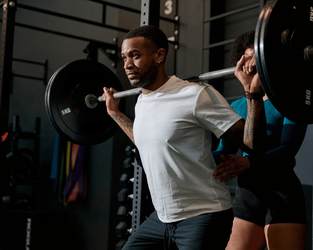 Athlete lifting weights inside a dark training gym