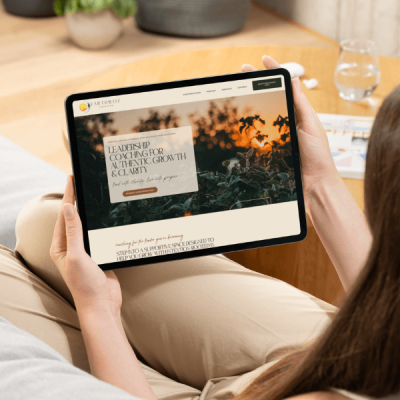 Woman on a couch holding a tablet showing Earth Wise Coaching homepage – custom coaching website design by Sprout Marketing and Design in Chandler, AZ